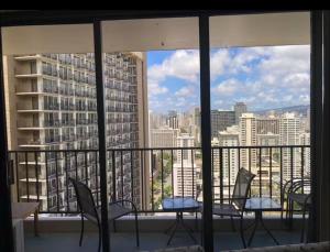 a balcony with chairs and a view of a city at Lovely APT AC, Free Parking, Ocean View in Honolulu +18 photos
