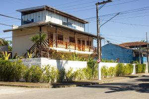 a house on the side of a street with a fence at Balangan Flats in Ubatuba