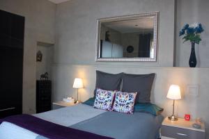 a bedroom with a bed with two lamps and a mirror at Appartement Jardin exotique in Cap d'Ail