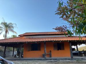 an orange house with a red roof at Chácara Carvalho in Sabará