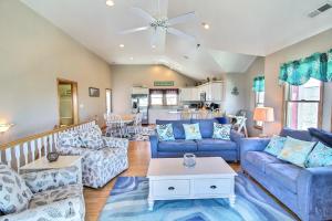 a living room with blue couches and a table at 5067 - The Diver Down in Kill Devil Hills
