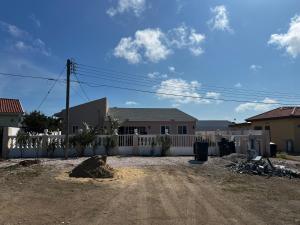 une maison avec une clôture blanche et un chemin de terre dans l'établissement Tanki flip Property 2, à Noord