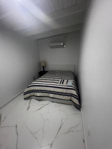 une chambre avec un lit dans une pièce blanche dans l'établissement Tanki flip Property 2, à Noord