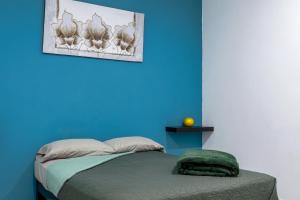a blue bedroom with a bed with a blue wall at Comodo depa vacacional in Mazatlán
