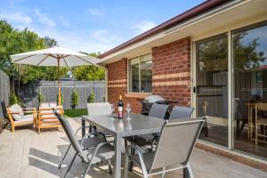 a patio with a table and chairs and an umbrella at SAUNA & ICE BATH! - Your Health Retreat Escape in Capel Sound