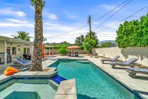 a swimming pool with chairs and a palm tree at Palm Springs Home with a Resort Style Backyard -Joy pool hot tub views in Palm Springs