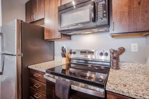 a kitchen with a stove and a refrigerator at TWO CozySuites at the Banks with Pool 18 in Cincinnati