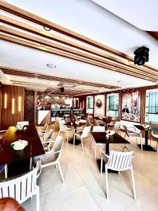 a restaurant with tables and chairs and a bar at Hôtel Réstinga Martil in Martil