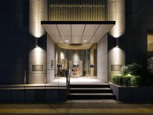 a lobby of a building with stairs in front at Hotel Monte Hermana Fukuoka in Fukuoka