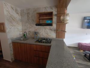 Cómodo Apartamento turístico Paipa في بايبا: مطبخ مع حوض وطاولة عمل