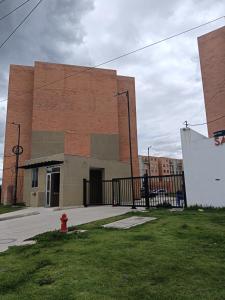 Cómodo Apartamento turístico Paipa في بايبا: مبنى من الطوب وامامه صنبور حرائق حمراء