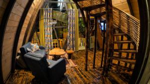 a living room with a chair and a staircase at JIJI VILL Merisi 1 in Inasharidzeebi +3 photos