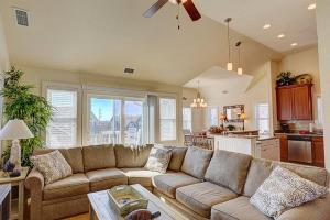 a living room with a couch and a kitchen at 6156 - Family Tides in Nags Head