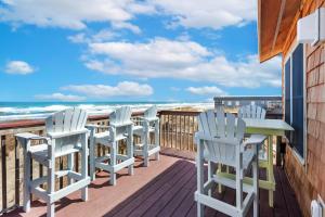 a deck with chairs and a table and the ocean at 7041 - Toes in the Sand in Whalebone