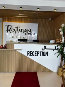 a reception area of a hotel with a red carpet at Hôtel Réstinga Martil in Martil