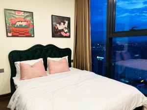 a bedroom with a bed with pink pillows and a window at 2-bedroom Doji apartment in hai phong in Hai Phong +14 photos