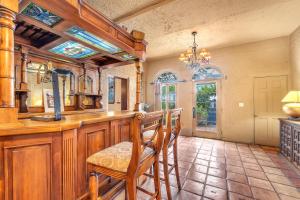 a kitchen with a bar with chairs and a chandelier at Young Mansion Steps To The Beach in Hollywood