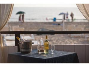ein Tisch mit zwei Gläsern und einer Flasche Wein in der Unterkunft Studio in Scoglitti, Sizilien in Scoglitti