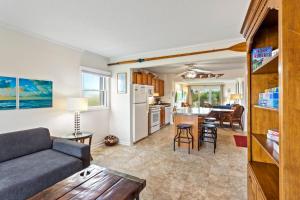 a living room and kitchen with a couch and a table at DL104 - Dune's Watch in Nags Head