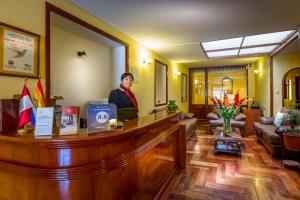 a man standing at a reception desk in a hotel lobby at El Virrey Boutique in Cusco