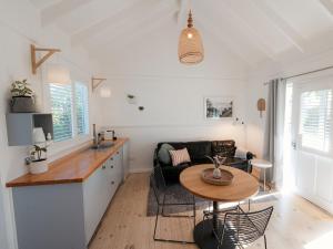 a kitchen and living room with a table and a couch at Beach Huts Middleton in Middleton