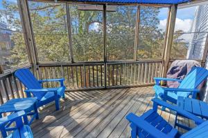 a screened porch with blue chairs and windows at OYG6 - Peace of Paradise in Kill Devil Hills