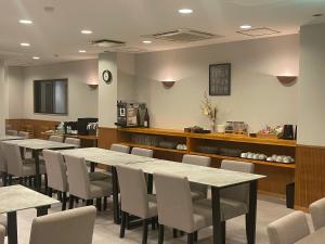 a restaurant with tables and chairs and a counter at Nagoya Premium Hotel in Inazawa