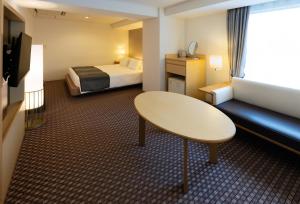 大阪Hotel Granvia Osaka-JR Hotel Group的小型酒店客房配有一张床和一张桌子