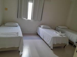 a room with two beds and a window at Pousada Oliveira in Remanso