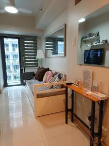 マニラにあるJoRan Staycation 1BR Unit near Moa with Netflixのソファとテレビのあるリビングルーム
