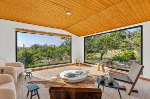 a living room with large windows and a table at Silent Place - Sintra in Paiõis