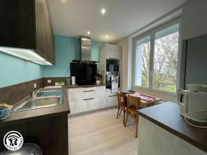 una cucina con un lavello e un piano di lavoro di Maison rénovée proche du Rocher de Cheffois avec Wifi - FR-1-426-587 a Cheffois
