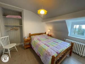 una camera da letto con un letto, una sedia e una finestra di Maison rénovée proche du Rocher de Cheffois avec Wifi - FR-1-426-587 a Cheffois