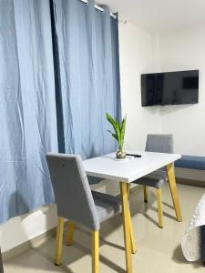 a white table with two chairs and a tv at Apartahotel MKS Caribe in San Andrés