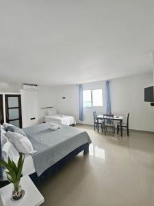 a white room with a bed and a dining room at Apartahotel MKS Caribe in San Andrés