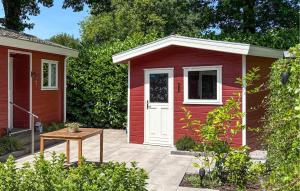 un cobertizo rojo con una puerta blanca y una mesa en Nice House In Putten, en Putten