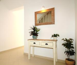 a white dressing table with two plants on it at Arolithos in Spetses