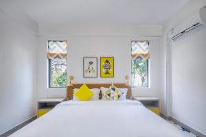 - une chambre avec un grand lit blanc et des fenêtres dans l'établissement Roy-Sanya Bay Coconut Dream Corridor, à Shuijiao