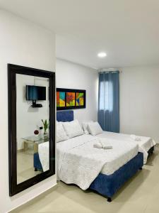 a bedroom with a large bed and a mirror at Apartahotel MKS Caribe in San Andrés