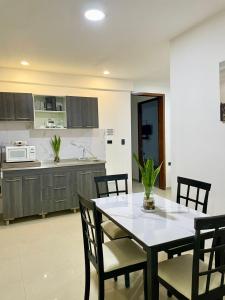 a kitchen with a table and chairs in a kitchen at Apartahotel MKS Caribe in San Andrés +72 photos