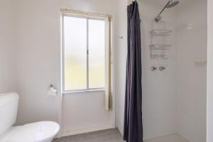 a bathroom with a shower and a toilet and a window at The Wreck Room, 6 Flannel Flower Fairway - fantastic house filled with activities for all in Shoal Bay +38 photos