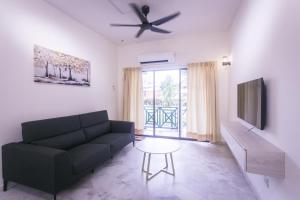 a living room with a couch and a tv at Bayu Beach Resort Apartment Seaview Private Beach in Port Dickson