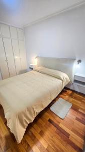 a large bed in a room with a wooden floor at Departamento centrico in Rosario