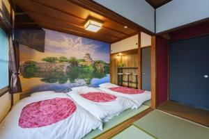 two beds in a room with a painting on the wall at SAMURAI Base in Hakone