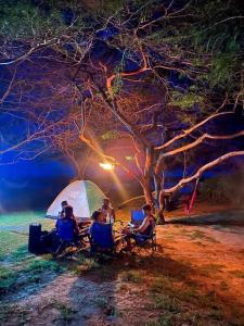 a group of people sitting in chairs in front of a tent at Yala Oruwella Beach Camping & Restaurants in Tissamaharama