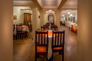 a dining room with a table and chairs and a bedroom at El Virrey by Katari in Cusco