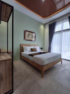 a bedroom with a bed and a large window at Sri Gaïa Yogyakarta in Imogiri +32 photos