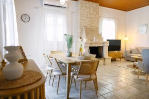 a living room with a table and chairs and a fireplace at EftychiaHouse in Pýrgos
