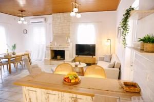 a living room with a couch and a table with a bowl of fruit at EftychiaHouse in Pyrgos
