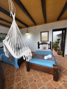 a bedroom with a bed with a hammock in it at AQUI ESTOY BIEN in Barichara